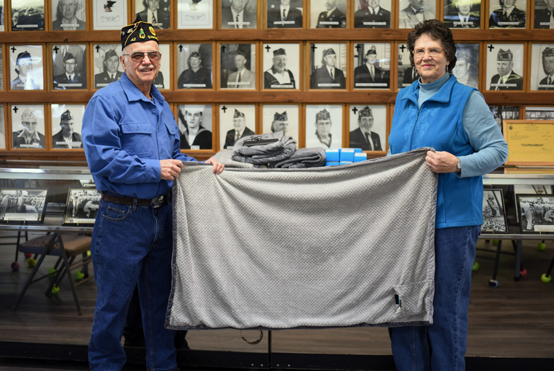 Mike and Shirley Johnson hold up an electric shoulder throw at The American Legion Wells-Hussey Post No. 42 in Damariscotta. The post donated several of the heated throws to the Togus Springs Hospice Unit in Augusta. (Jessica Picard photo)