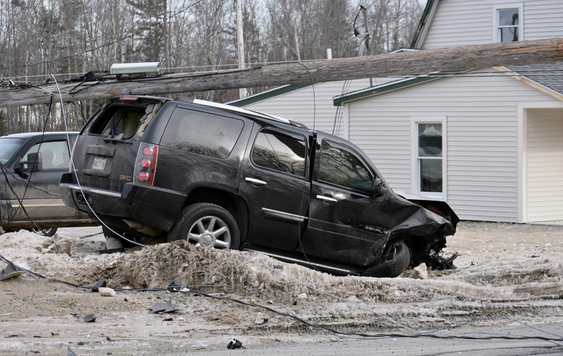 A utility pole rests atop a GMC Yukon Denali SUV after a two-vehicle collision on Route 1 in Waldoboro on Tuesday, Feb. 12. Another SUV entering Route 1 did not yield the right of way, according to police. (Alexander Violo photo)