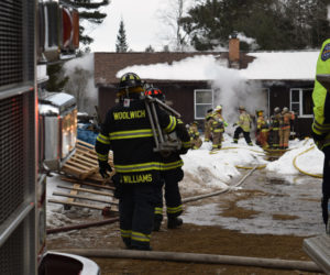 Woolwich firefighters carry a ladder toward a home on fire at 48 Greenleaf Road in Wesport Island on Wednesday, Feb. 27. (Jessica Clifford photo)