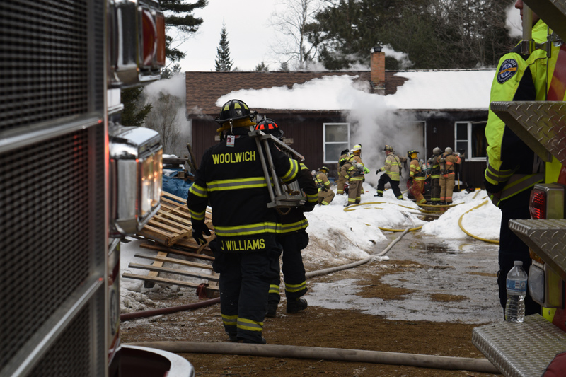 Woolwich firefighters carry a ladder toward a home on fire at 48 Greenleaf Road in Wesport Island on Wednesday, Feb. 27. (Jessica Clifford photo)