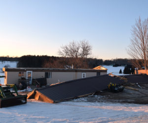 The metal roof of a mobile home at 45 Townhouse Road in Whitefield lies on the ground in front of the home Tuesday, Feb. 26 after blowing off during high winds the previous night. (Jessica Clifford photo)