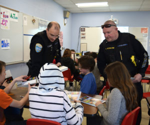 From left: Wiscasset School Resource Officer Cory Hubert and Wiscasset Police Chief Larry Hesseltine hand out name tags to fifth-graders during the first day of a D.A.R.E. class at Wiscasset Elementary School on Thursday, Feb. 28. (Jessica Clifford photo)