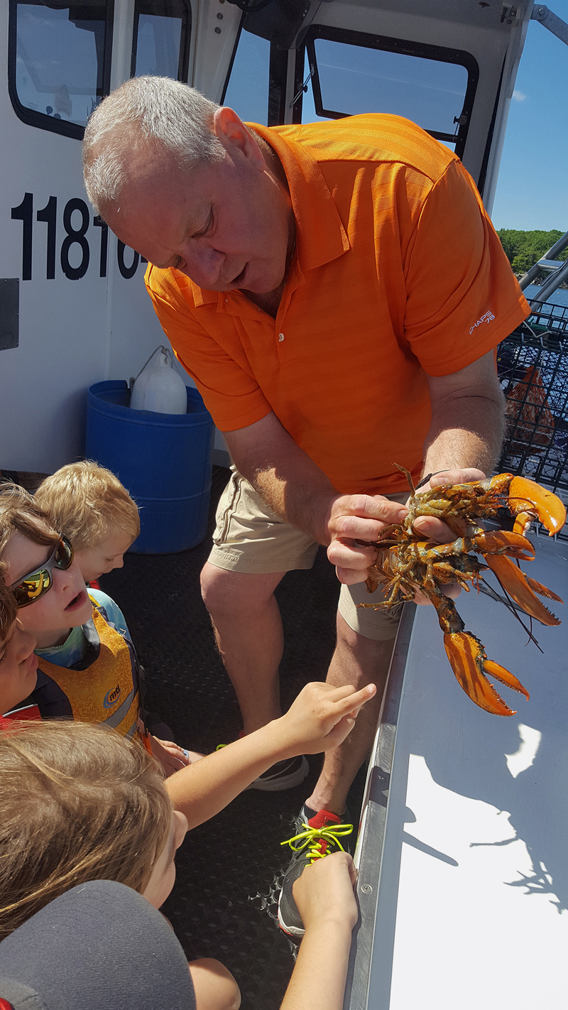 Lobsterman Tim Alley talks to Camp Mummichog campers about lobster anatomy on a camp field trip.