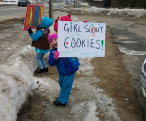 A member of Daisy and Brownie Girl Scout Troop No. 1145 sells cookies.