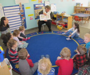 Patty Lane, of Bath Savings Institution, reads to children at Coastal Kids Preschool in Damariscotta.