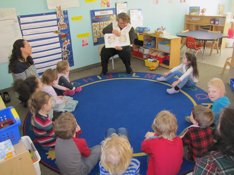 Patty Lane, of Bath Savings Institution, reads to children at Coastal Kids Preschool in Damariscotta.