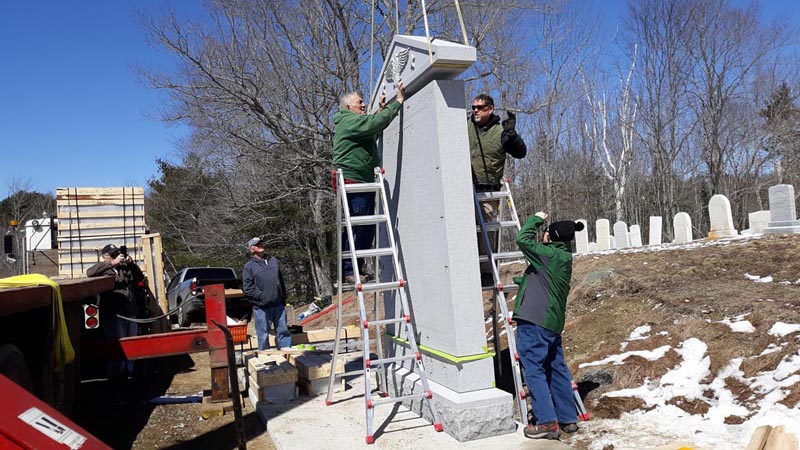 Eighty-two-year-old monument setter Francis Tash, of Barre, Vt., guides the top piece of a monument into place at West Bristol Cemetery in Walpole on Thursday, April 11. Thomas A. Stevens Cemetery Memorials, of Newcastle, and subcontractors worked throughout the day to set up South Bristol's new veterans memorial. (Candy Congdon photo)