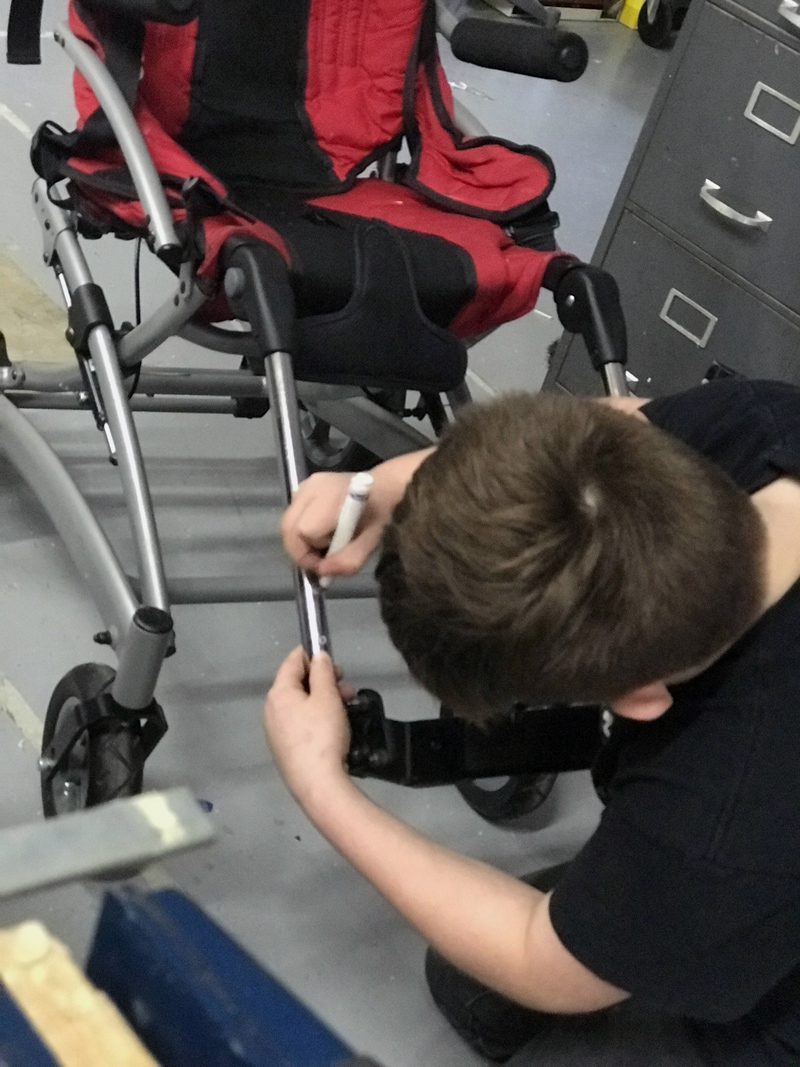 Camden Larrabee works on a pedal extension for a 12-year-old girl's wheelchair. (Photo courtesy Rachel Hamlin)