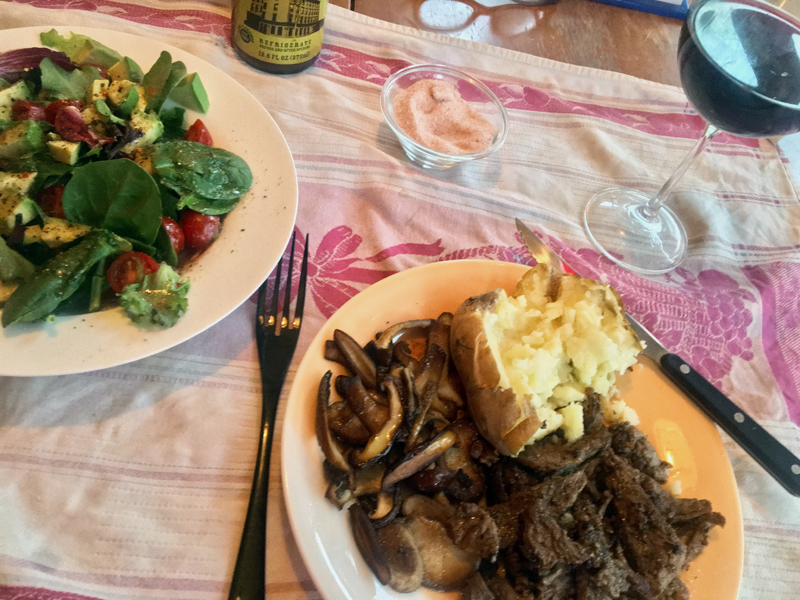 Sliced pan-fried New York sirloin with 'shrooms sauteed in butter, a baked potato, and a salad. (Suzi Thayer photo)