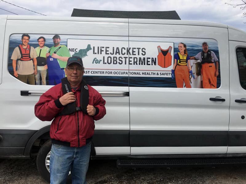 Lobsterman and Round Pond Harbor Master Robert Ball models his new personal flotation device from Lifejackets for Lobstermen during the campaign's visit to Round Pond on May 7. (Photo courtesy Amanda Roome)