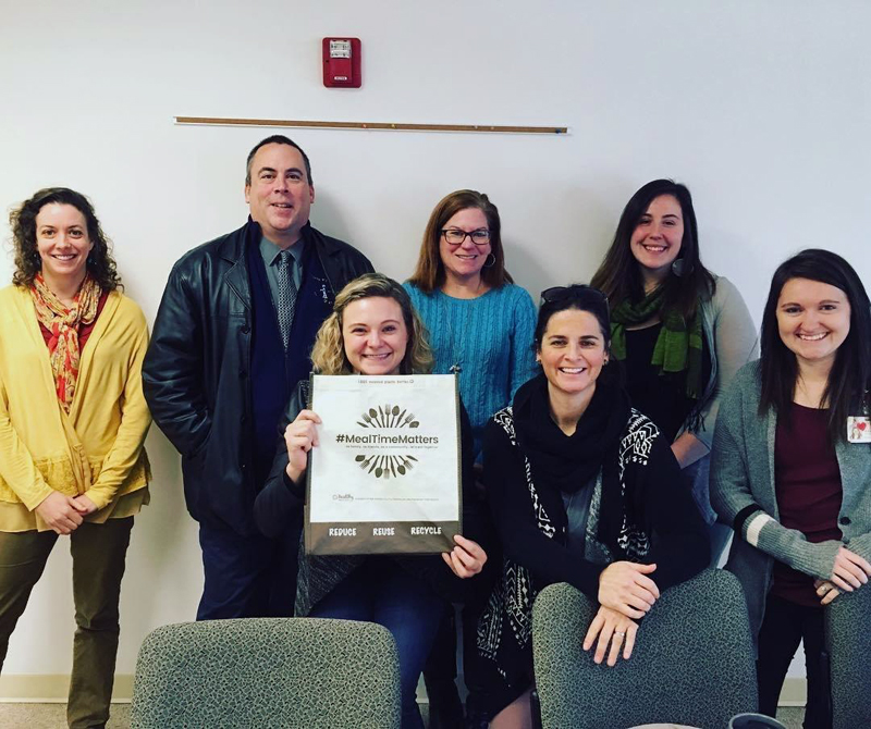 SUPP Coalition members pose with a bag they designed for local food pantries.  The bags promote the benefits of eating meals together to prevent substance use.