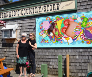Edgecomb artist and educator Brady Nickerson (left) poses with Bremen artist Katie Riley after the unveiling of Riley's mural on S. Fernald's Country Store in downtown Damariscotta on Saturday, June 15. (Evan Houk photo)