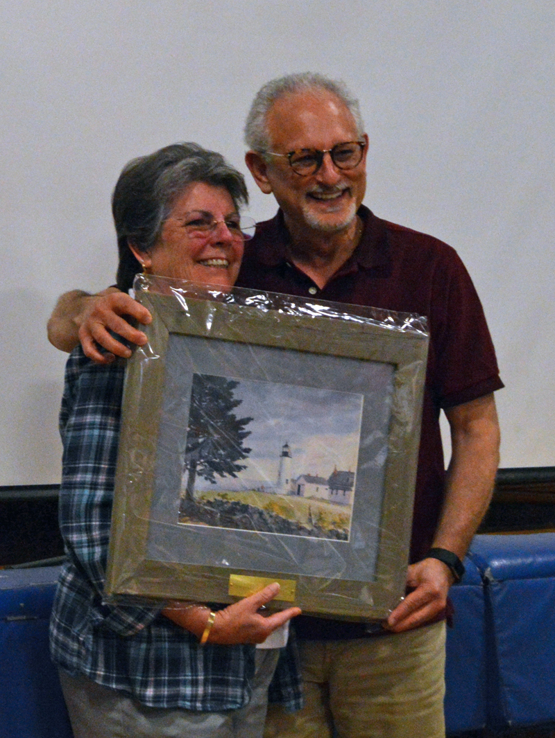 Damariscotta Board of Selectmen Chair Robin Mayer presents outgoing Selectman Ronn Orenstein with a portrait in recognition of his nine years of service at annual town meeting June 12. (Evan Houk photo)