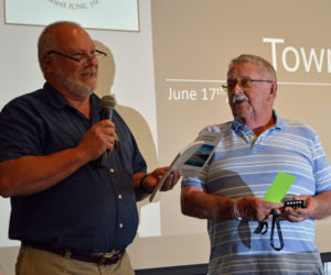 Newcastle Board of Selectmen Chair Brian Foote (left) dedicates the annual town report to Allan Ray at annual town meeting Monday, June 17. (Evan Houk photo)