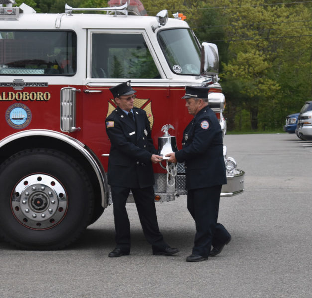 John Emerson (left) and William Bragg, of the Waldoboro Fire Department, remove the bell from Ladder 1. The bell will go on the town's new ladder truck. (Alexander Violo photo)