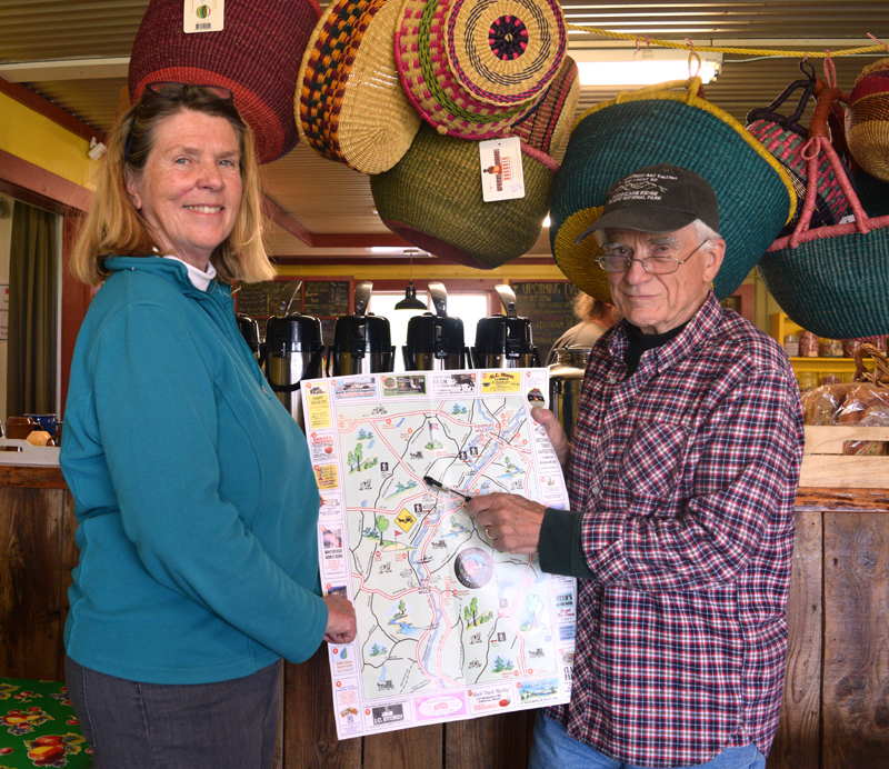 Libbey Seigars, one of the volunteers behind the new Whitefield map and guide, and Bill McKeen, Whitefield selectman and leader of the group, hold up an unfolded copy of the map. (Jessica Clifford photo)