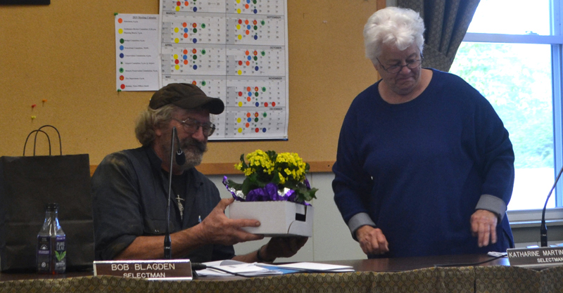 Outgoing Wiscasset Selectman Robert Blagden accepts a gift of flowers from Selectman Katharine Martin-Savage in appreciation of his service to the town. (Charlotte Boynton photo)