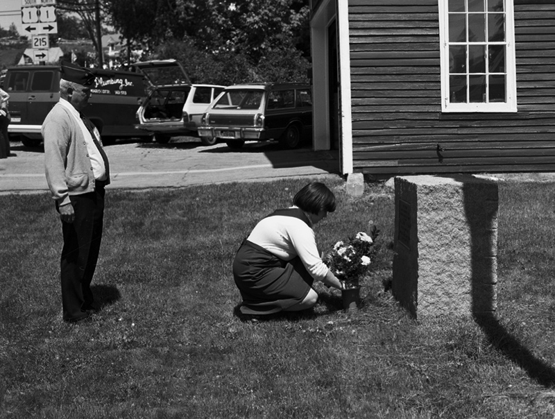 A Girl Scout at an early Memorial Day parade placing flowers at the Newcastle memorial at the corner of the old fire house, which is now the museum. (Photo courtesy Newcastle Historical Society museum)