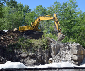 A backhoe begins to demolish the right abutment of the Head Tide Dam in Alna on Thursday, July 25. (Jessica Clifford photo)