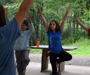 From left: Lina Remer, Gabriela Dotson, and Lydia Glidden demonstrate a yoga pose during the closing circle of a Hearty Roots camp at Hidden Valley Nature Center in Jefferson on Friday, July 12. (Jessica Clifford photo)