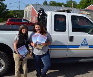 Melissa Temple, deputy director of the Lincoln County Emergency Management Agency, and Maia Zewert, marketing and engagement coordinator for Lincoln County Publishing Co., hold copies of the 2019 Lincoln County Road Atlas. (John Roberts photo)