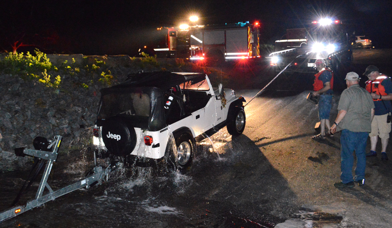 A 1987 Jeep Wrangler sheds water as Quick Turn Auto Repair and Towing Inc., of Damariscotta, pulls it back onto the boat ramp at Eugley Landing in South Bristol the night of Monday, July 29. (Evan Houk photo)