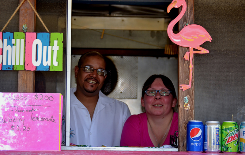 Alex Echevarria and Daisey Cunningham, of Wiscasset, stand behind the counter of their Puerto Rican food stand, Maritza's Place, at Montsweag Flea Market in Woolwich on July 3. (Nettie Hoagland photo)