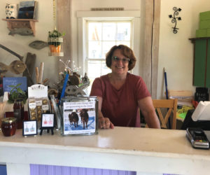 Board member and store volunteer Lori Bryant stands behind the counter of the Morris Farm Store.