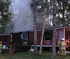 Firefighters cool down a smoldering mobile home at 3 Left Lane in Pemaquid early Monday, Aug. 26. The home was vacant, according to the fire chief. (J.W. Oliver photo)