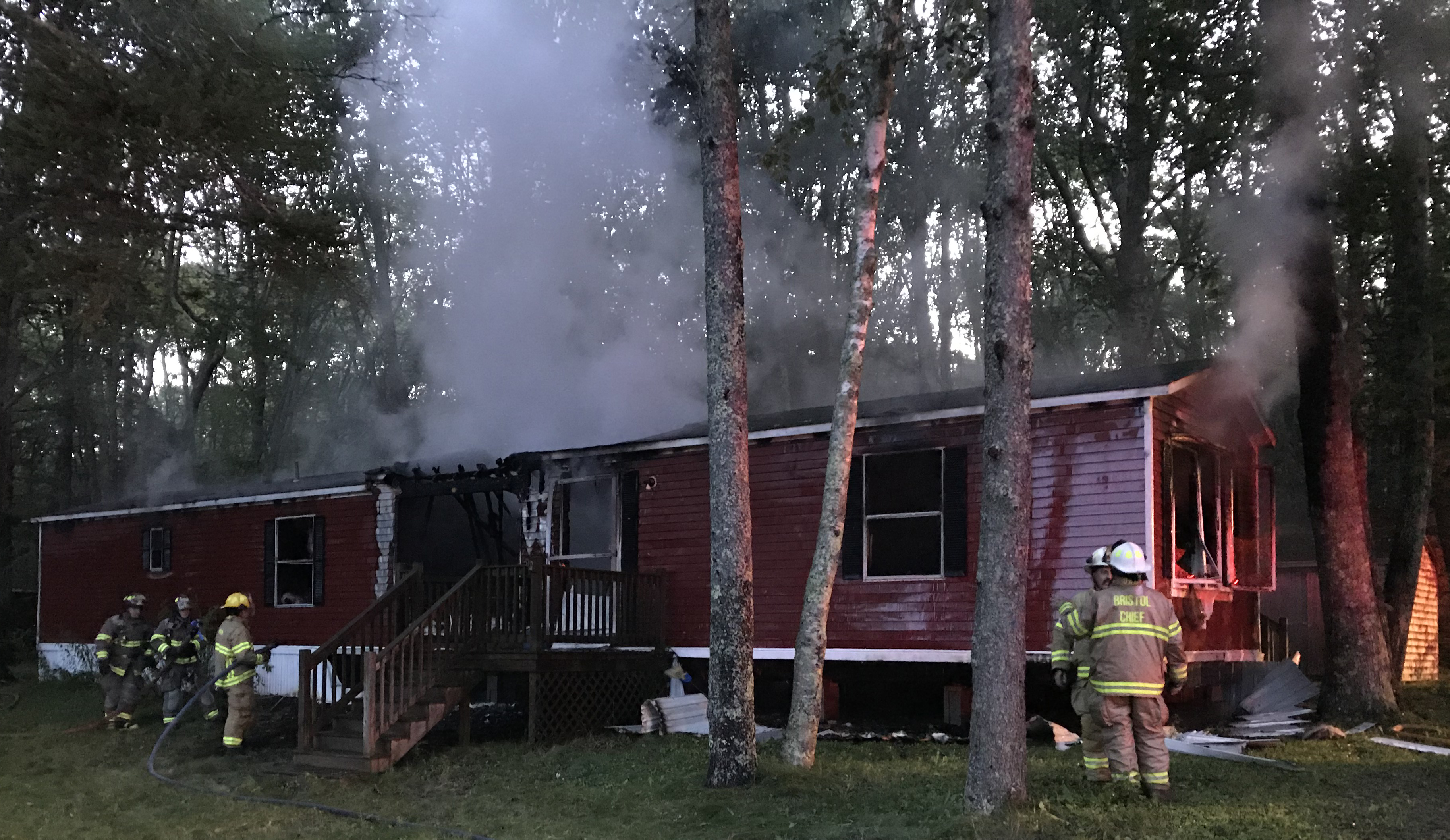 Firefighters cool down a smoldering mobile home at 3 Left Lane in Pemaquid early Monday, Aug. 26. The home was vacant, according to the fire chief. (J.W. Oliver photo)