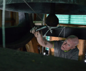 Rob Gregory adjusts the tension on the pulley system he devised that will allow the manual ringing of the bell at Damariscotta Baptist Church to continue, despite the installation of automatic controls. (Evan Houk photo)
