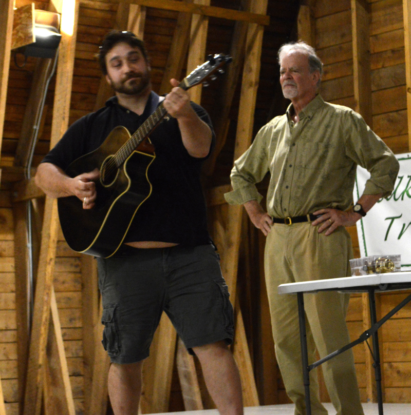 Gianni Barbera strums a parody of Simon & Garfunkel's "The Sound of Silence," singing about the "rising mound of garbage" as Michael Uhl looks on during the "Talking Trash!" forum at Darrows Barn in Damariscotta on Thursday, Aug. 22. (Evan Houk photo)