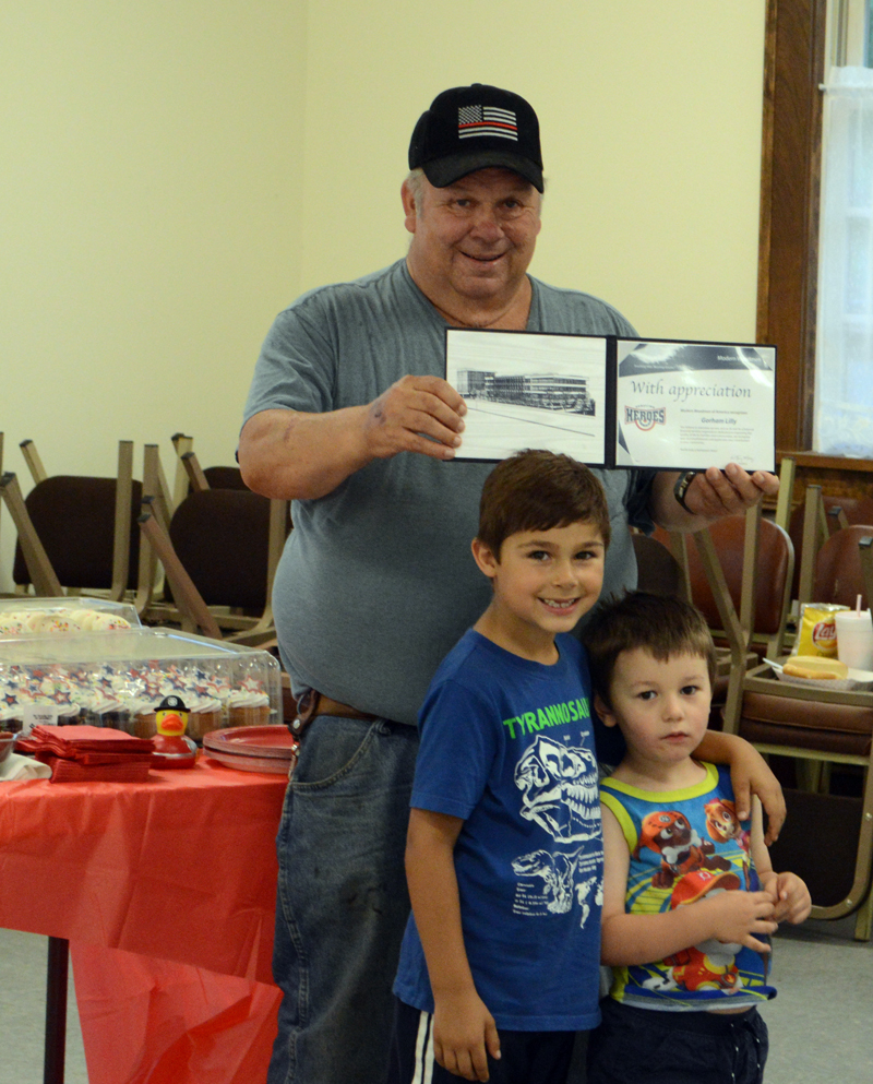 Capt. Gorham Lilly, of the Dresden Fire Department, displays his Hometown Hero award with his grandsons, Spencer Lilly (left) and Liam Aarons. The Modern Woodmen of America Hometown Heroes Program presented the award to Lilly for his 57 years of service to the department. (Evan Houk photo)