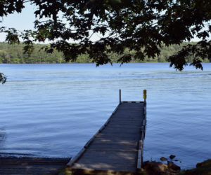 A pontoon boat cruises by the boat ramp on Damariscotta Lake in Jefferson. (Alexander Violo photo)