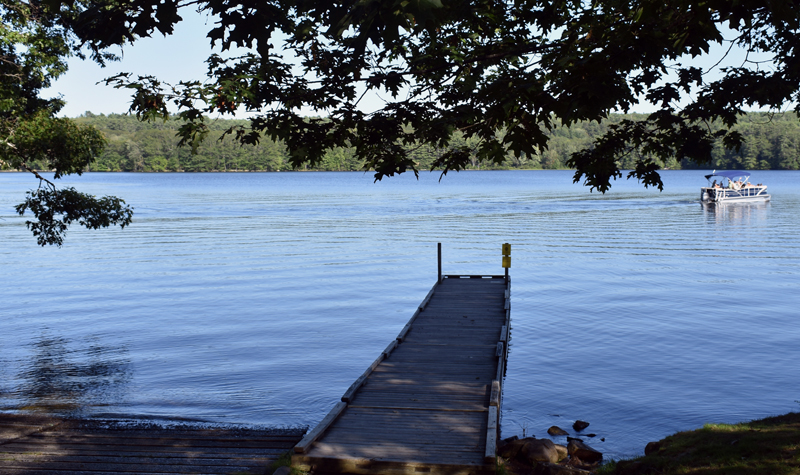 A pontoon boat cruises by the boat ramp on Damariscotta Lake in Jefferson. (Alexander Violo photo)