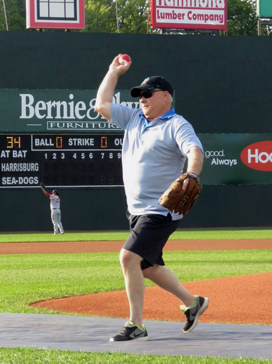 Lincoln County Sheriff's Office Sgt. Mark Bridgham throws out the first pitch of a Portland Sea Dogs game at Hadlock Field in Portland on Saturday, July 27, part of a surprise retirement and birthday celebration with his family. (Photo courtesy Portland Sea Dogs)