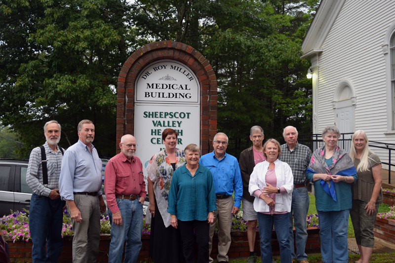 The Sheepscot Valley Health Center Board of Directors poses with Lisa and Dr. Roy Miller in front of the new sign for the Dr. Roy Miller Medical Building. (Jessica Clifford photo)