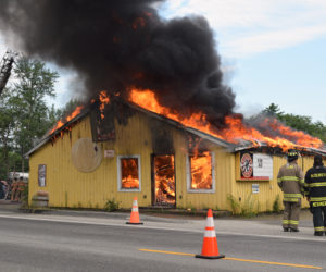 Local firefighters watch the circa-1960s Huber's Market building go up in flames during a training exercise in Wiscasset on Sunday, Aug. 4. The site will become part of the parking lot for a new Dollar General store. (Jessica Clifford photo)