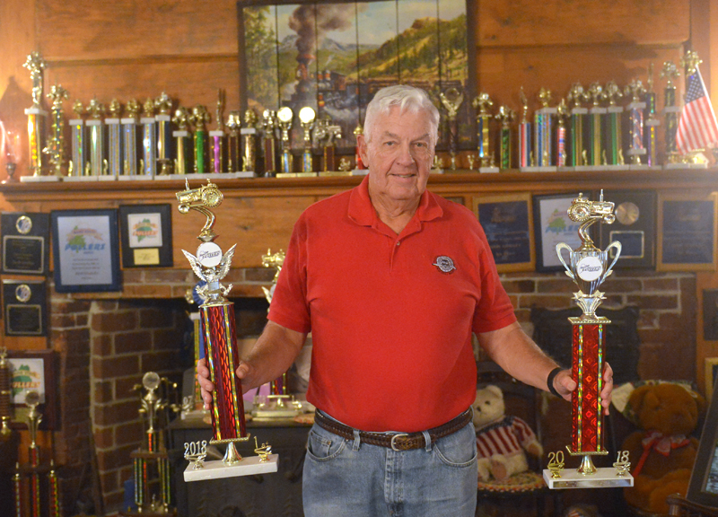 Jack Studley holds two 2018 point series championship trophies. The mantel of Jack and Grayce's 1791 Hall House in Nobleboro is loaded with trophies he has won pulling tractors at Maine fairs. (Paula Roberts photo)