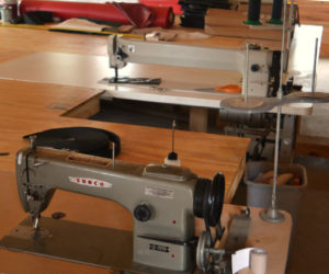 The industrial sewing machines at Benjamin Zook's Cooper Canvas shop in Whitefield. The machine at rear measures a yard across. (Christine LaPado-Breglia photo)