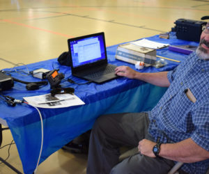 Karl Richards, of Lincoln County Amateur Radio, sends an email by amateur radio to his counterpart in a van in the Central Lincoln County YMCA parking lot. Lincoln County Amateur Radio was one of 34 organizations and vendors set up at the inaugural Lincoln County Emergency Preparedness Fair. (Evan Houk photo)