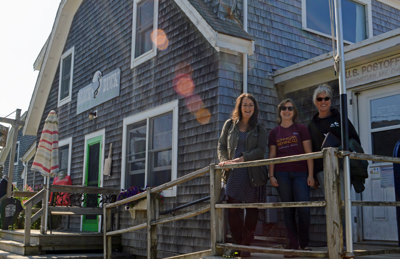 From left: Monhegan Island Sustainable Community Association Co-president Rebecca FitzPatrick, Secretary Carley Feibusch, and Co-president Joan Brady at the association's first building, which now serves as a focal point of island life. (Evan Houk photo)