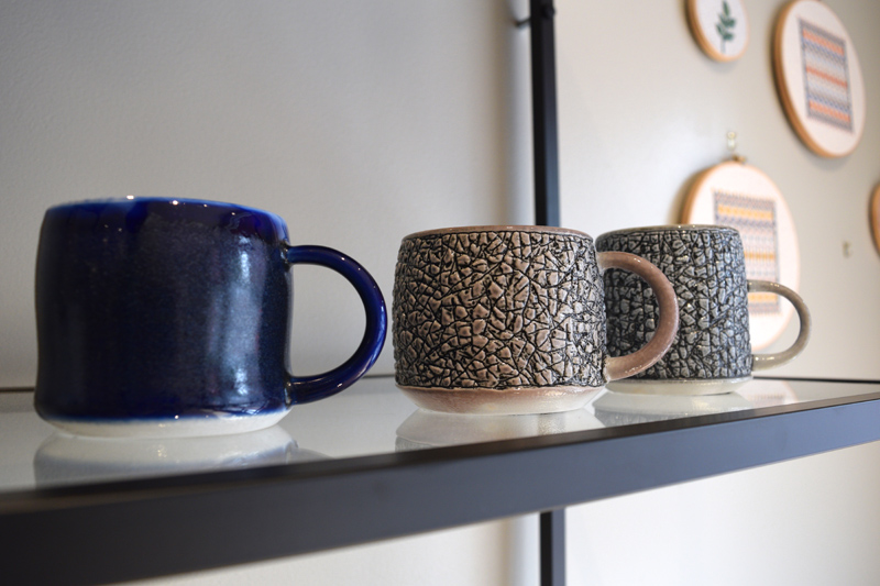 A few of Midcoast Craft co-owner Dennis Chouinard's mugs on display. (Jessica Clifford photo)