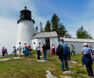 Participants visit the Burnt Island Lighthouse during a Maine Maritime Museum Lighthouse Legends and Lore Cruise with Red Cloak Tours.