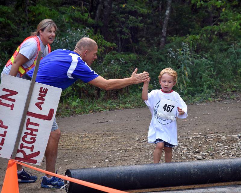 A volunteer high-fives a racer.