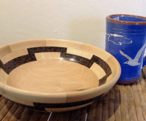 A wooden bowl created by Tom Raymond and a ceramic mug made by Libbey Seigars.