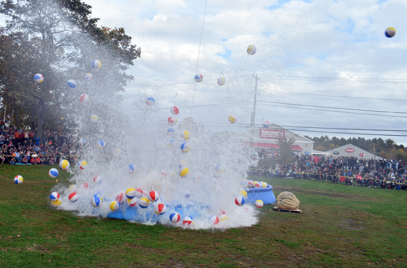 Beach balls and water fly as the first giant pumpkin touches down from its 180-foot journey into an inflatable swimming pool during the pumpkin drop at Round Top Farm in Damariscotta on Sunday, Oct. 13. (Evan Houk photo)