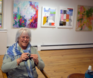 Freeport fiber artist C.S. Peterson knits while manning the "Abstraction" exhibit at River Arts in Damariscotta on opening day, Friday, Oct. 25. (Christine LaPado-Breglia photo)