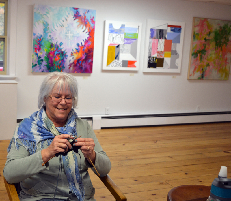 Freeport fiber artist C.S. Peterson knits while manning the "Abstraction" exhibit at River Arts in Damariscotta on opening day, Friday, Oct. 25. (Christine LaPado-Breglia photo)