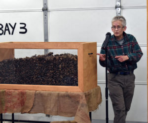 Mary Winchenbach, founder and owner of Tirdy Works, gestures toward a box of moose droppings during a television shoot at the Somerville fire station Thursday, Oct. 24. (Alexander Violo photo)